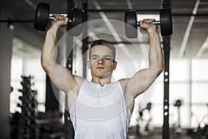 Bodybuilder working out with dumbbell weights at the gym. Man bodybuilder doing exercises with dumbbell. Fitness muscular body