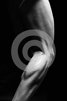 bodybuilders legs. Naked muscular male part in the Dark