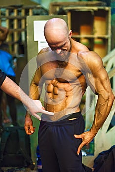 Bodybuilding contest behind the scenes: the contestant is preparing for the performance.