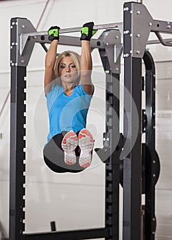 Bodybuilding. Strong fit woman exercising in a gym - doing pull-ups.