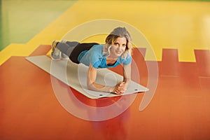 Bodybuilding. woman exercising on mat in fitness class. Female workout in gym doing plank