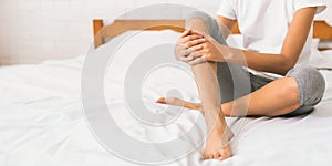 Bodycare. Woman with bare legs sitting on bed