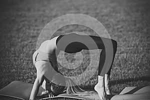Bodycare woman in crab position on green grass, body care