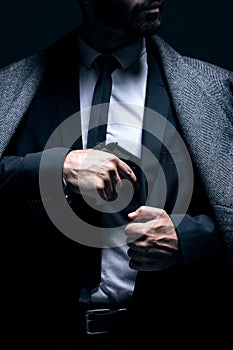 Bodyguard, hands or gun in suit jacket on studio background in dark secret spy or isolated mafia leadership. Gangster