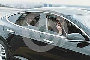 bodyguard sitting in car with businessman