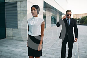 Bodyguard in sunglasses and black business woman