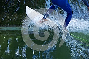 Bodypart of a surfer surfing on the flowings water