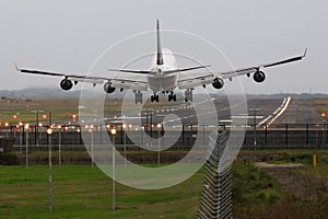 Boeing 747 jumbo jet landing on runway.