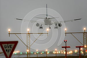 Boeing 767 landing with runway lights on.