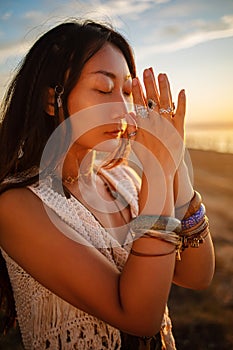 Bohemian chic gypsy happy free asian woman with manicure wearing hands jewelry accessories and white dress.