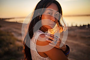 Bohemian chic gypsy happy free asian woman with manicure wearing hands jewelry accessories and white dress.