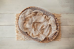 Bohemian rustic newborn background - white bowl with macrame and dry wheat on white wooden floor