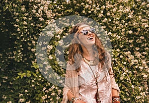 Bohemian young woman among flowers looking up on copy space