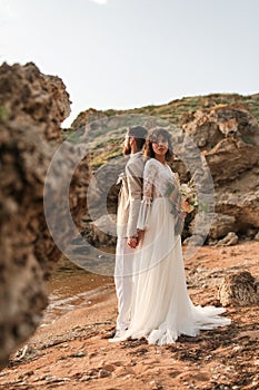 Boho bouquet of roses in the hands of the bride. Weddind couple boho style.