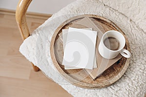 Boho breakfast still life scene. Blank greeting card, invitation. Book, cup of coffee. Wooden tray. Stationery mock-up