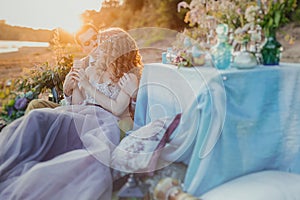 Boho chic couple in love the bride and groom. Wedding inspiration picnic outdoors, with the dinner table and decor in turquoise co