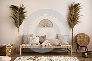 Boho composition of meditation living room interior with couch, beige carpet, pillows, ornament and personal accessories. Home