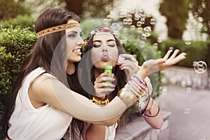 Boho girls playing with bubbles