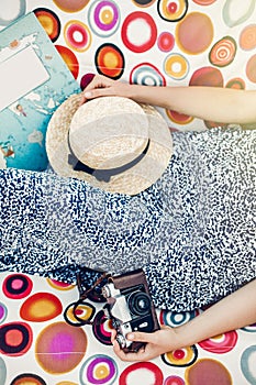 Boho hipster girl with retro camera, book and straw hat relaxing in hammock on summer vacation in sun light. top view. woman