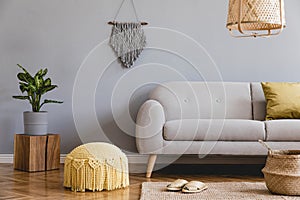 Boho living room with grey sofa, large poster and natural accessories. Cosy home decor.