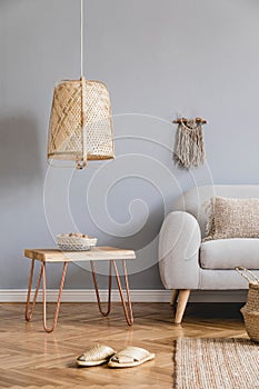 Boho living room with grey sofa and natural accessories. Cosy home decor.