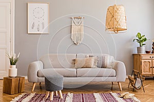 Boho living room with grey sofa and natural accessories. Cosy home decor.