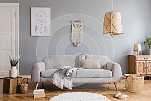 Boho living room with grey sofa and natural accessories. Cosy home decor. photo