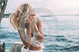 Boho model wearing crochet top and silver jewelry on the beach