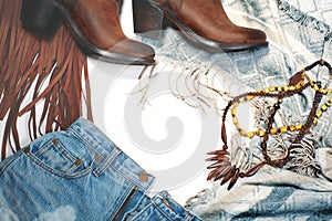 Boho Style. Leather Boots, Denim and Bag with Fringe on White Background. Overhead View Casual Day Outfits. Trendy Look.