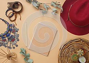 Boho style modern minimal home workspace desk with notebook, succulent, hat, aroma sticks, napkins on beige background.