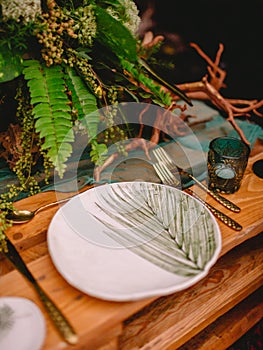 Boho table setting with a blank card decorated with fern branches close up, Wedding Mockup. Romantic table with paper invitation