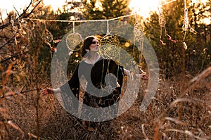 Boho style woman dancing near dreamcatchers. Female  freedom,  witch, gypsy style concept photo