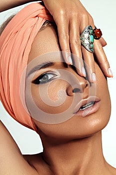 Boho Woman wearing Turban with Bohemian Accessories, Rings, Fashion Make-up. Tan Smooth Skin, Dark Makeup and Manicure