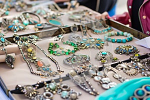 bohothemed jewelry display on a flea market table with a person browsing