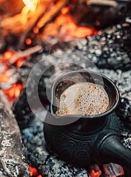 Boil coffee on turkish cezva on campfire coals photo