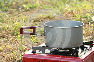 boil something in pot on gas stove on grass background for camping