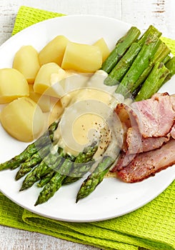 Boiled asparagus, potatoes, bacon and hollands sauce photo