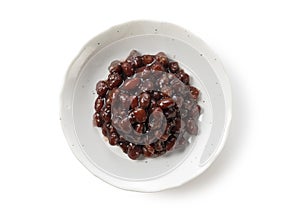 Boiled azuki beans in a dish placed on a white background