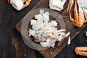 Boiled blue swimming crab claws, on wooden cutting board, on dark wooden background, top view flat lay