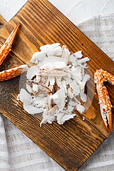 Boiled blue swimming crab claws, on wooden cutting board, on white background, top view flat lay