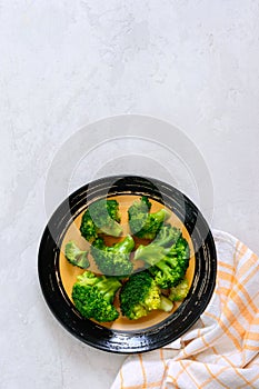 Boiled broccoli on a plate on a light background. Healthy eating concept. Sports diet. Proper nutrition. Healthy lifestyle. Free