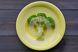 Boiled broccoli on a yellow plate
