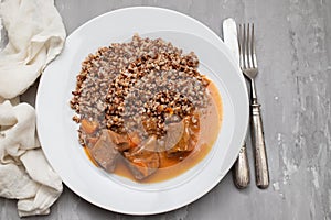Boiled buckwheat with meat and sauce on white dish