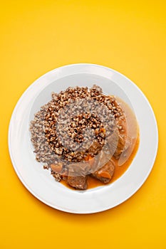 Boiled buckwheat with meat and sauce on white dish