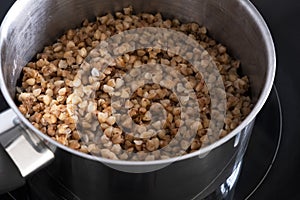 Boiled buckwheat in a metal pan. Prepare food. Healthly food. Carbohydrates