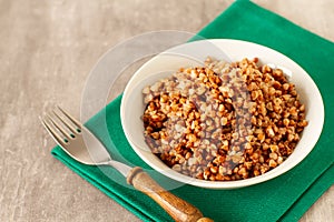 Boiled buckwheat in a plate on a stone table