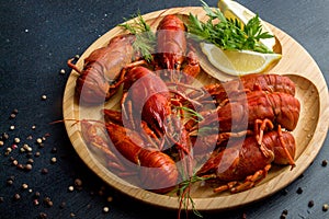 Boiled cooked crayfish crawfish ready to eat on wooden plate on