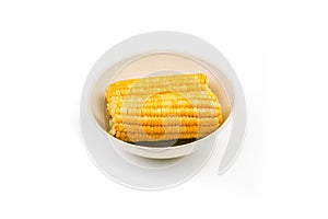 Boiled corn on a plate on a white background. Isolate. Close-up