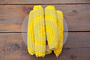 Boiled corn on a wooden table photo