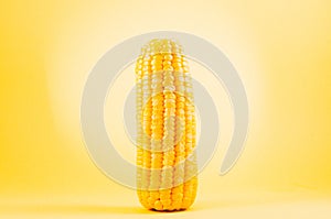 Boiled corn on a yellow background/boiled appetizing corn on a yellow background, close up